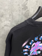 Black T-shirt shoulder with partial neon music graphic