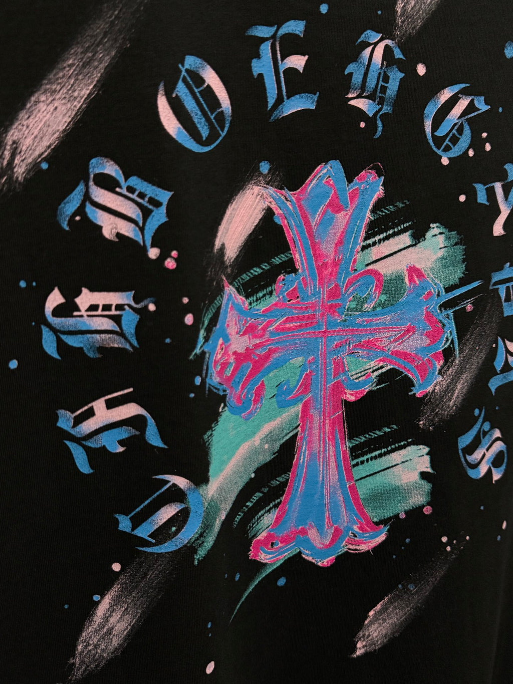 Close-up of neon blue and pink music graphic on black T-shirt