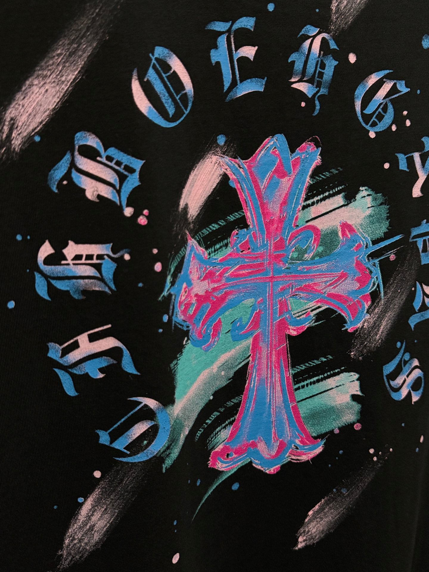 Close-up of neon blue and pink music graphic on black T-shirt
