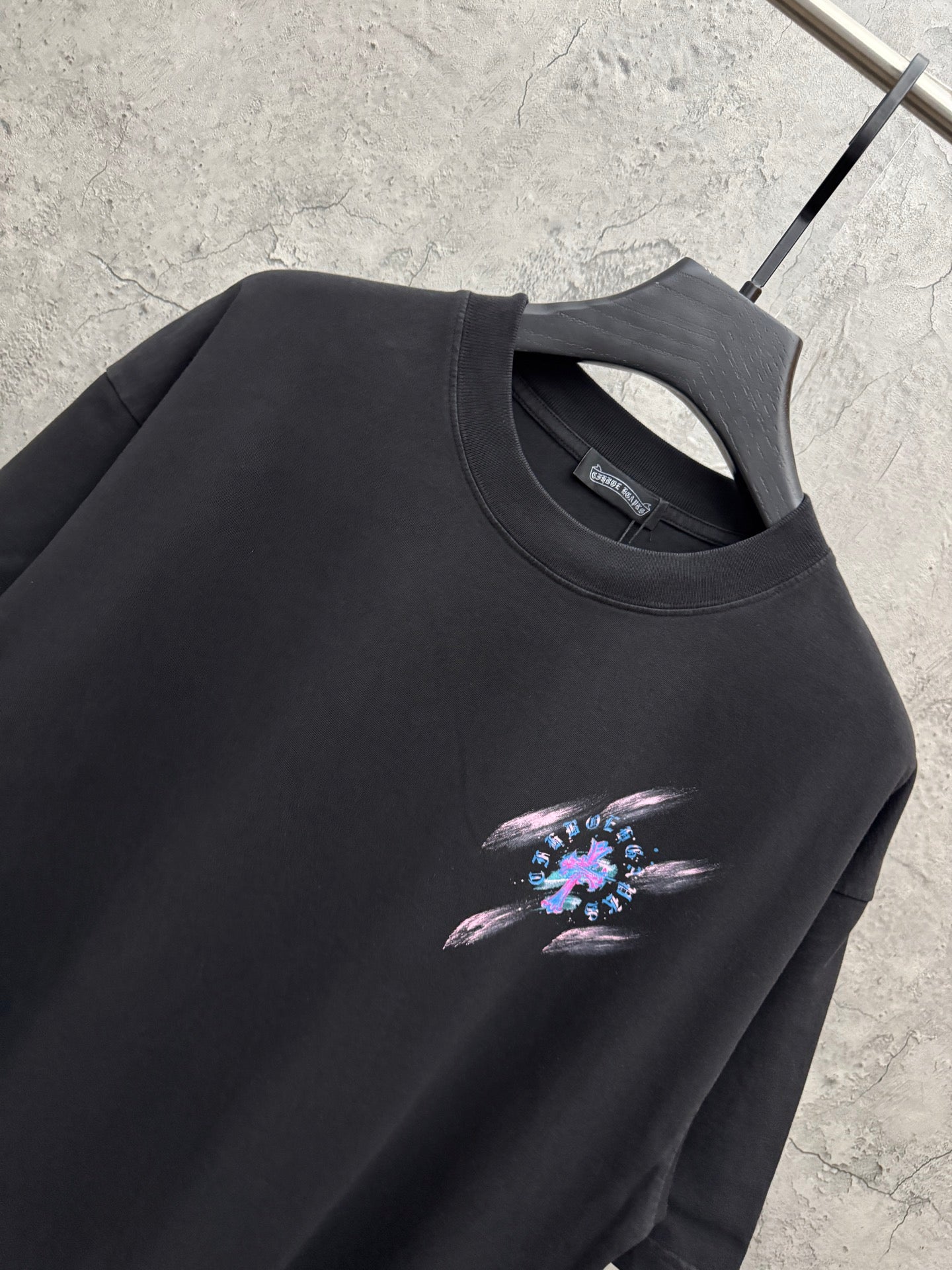 Black short-sleeve T-shirt with crew neck and small neon music graphic