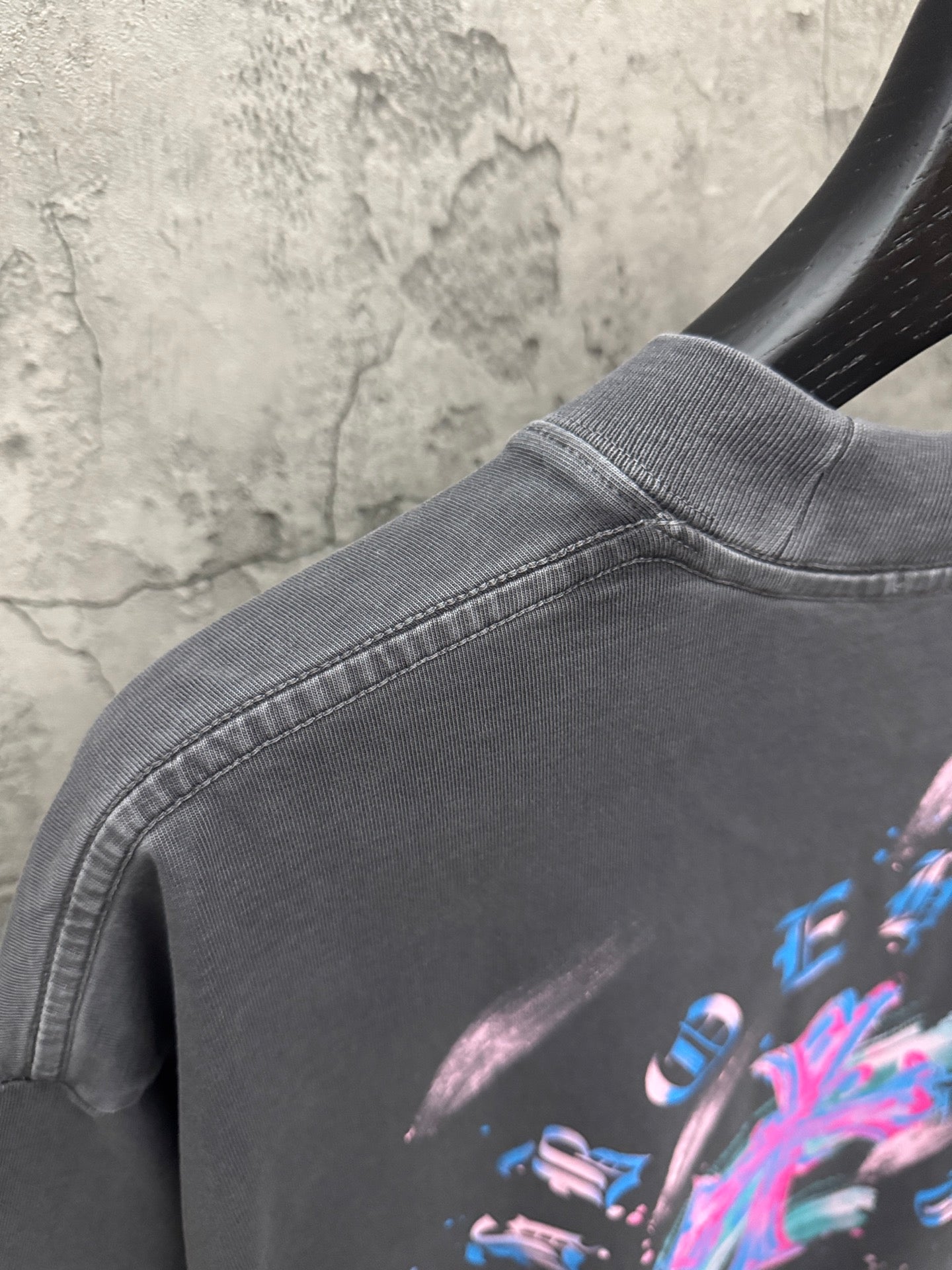 Dark gray T-shirt back collar and shoulder seam with colorful cross graphic detail