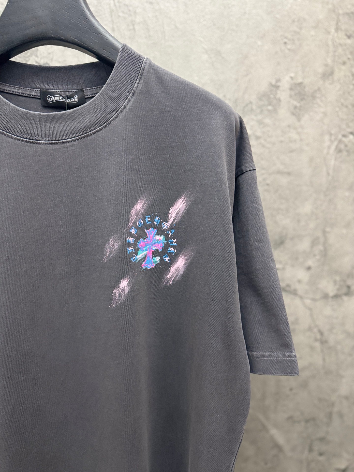 Dark gray short-sleeve T-shirt with small colorful cross graphic on front