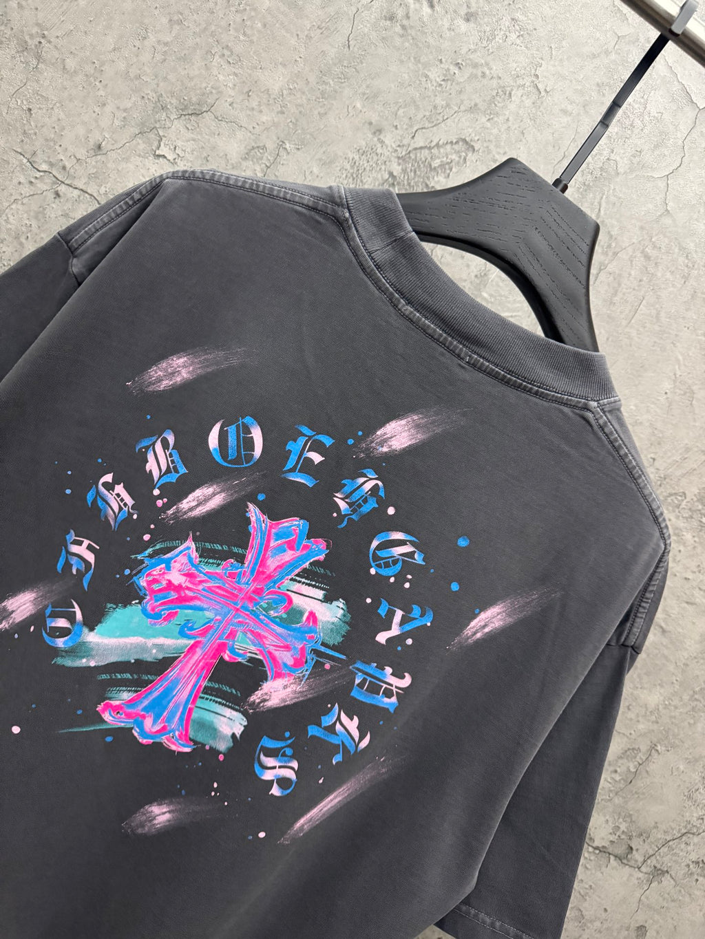Dark gray short-sleeve T-shirt close-up with large colorful cross graphic on back