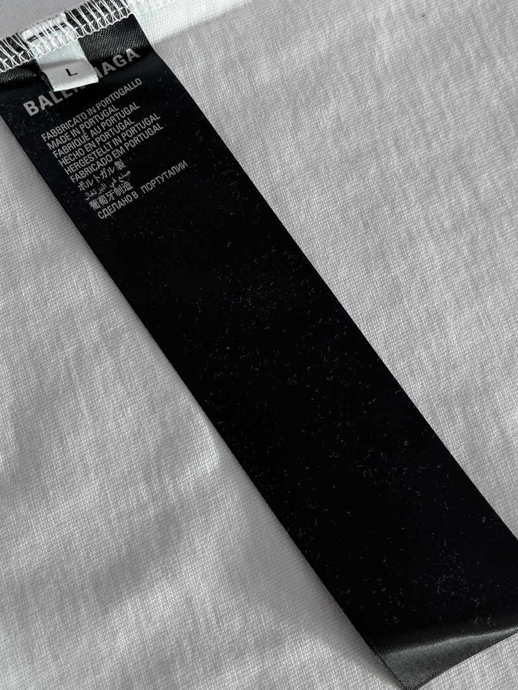 Black fabric care tag with size and text on Balenciaga T-shirt