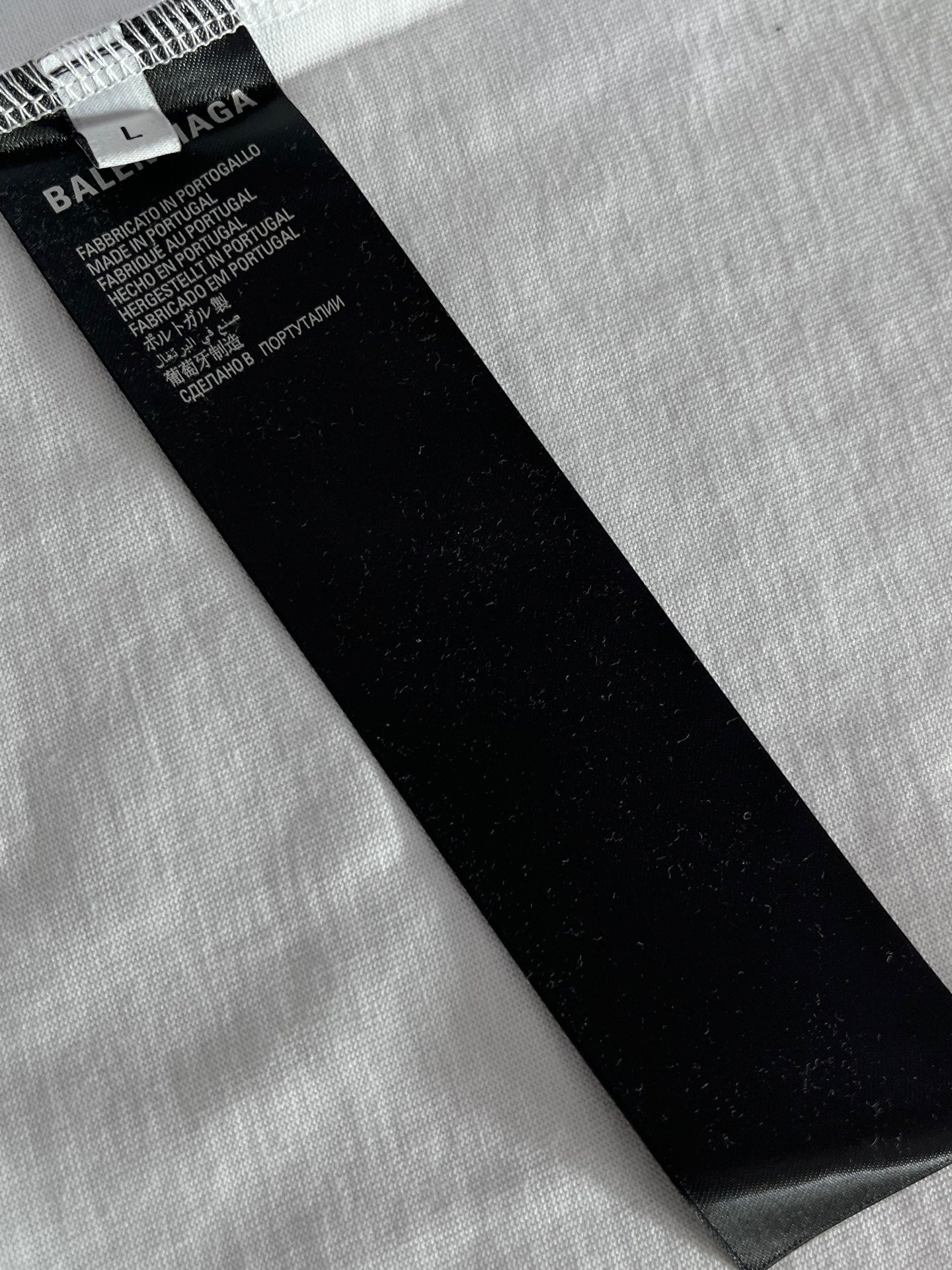 Black fabric care tag with size and text on Balenciaga T-shirt