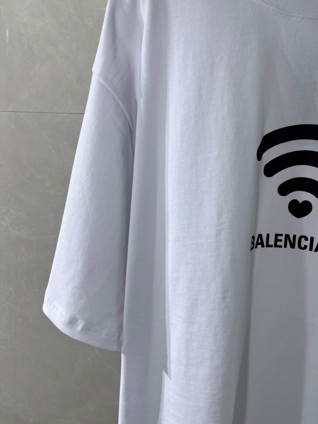 White Balenciaga T-shirt sleeve with partial Wi-Fi heart graphic