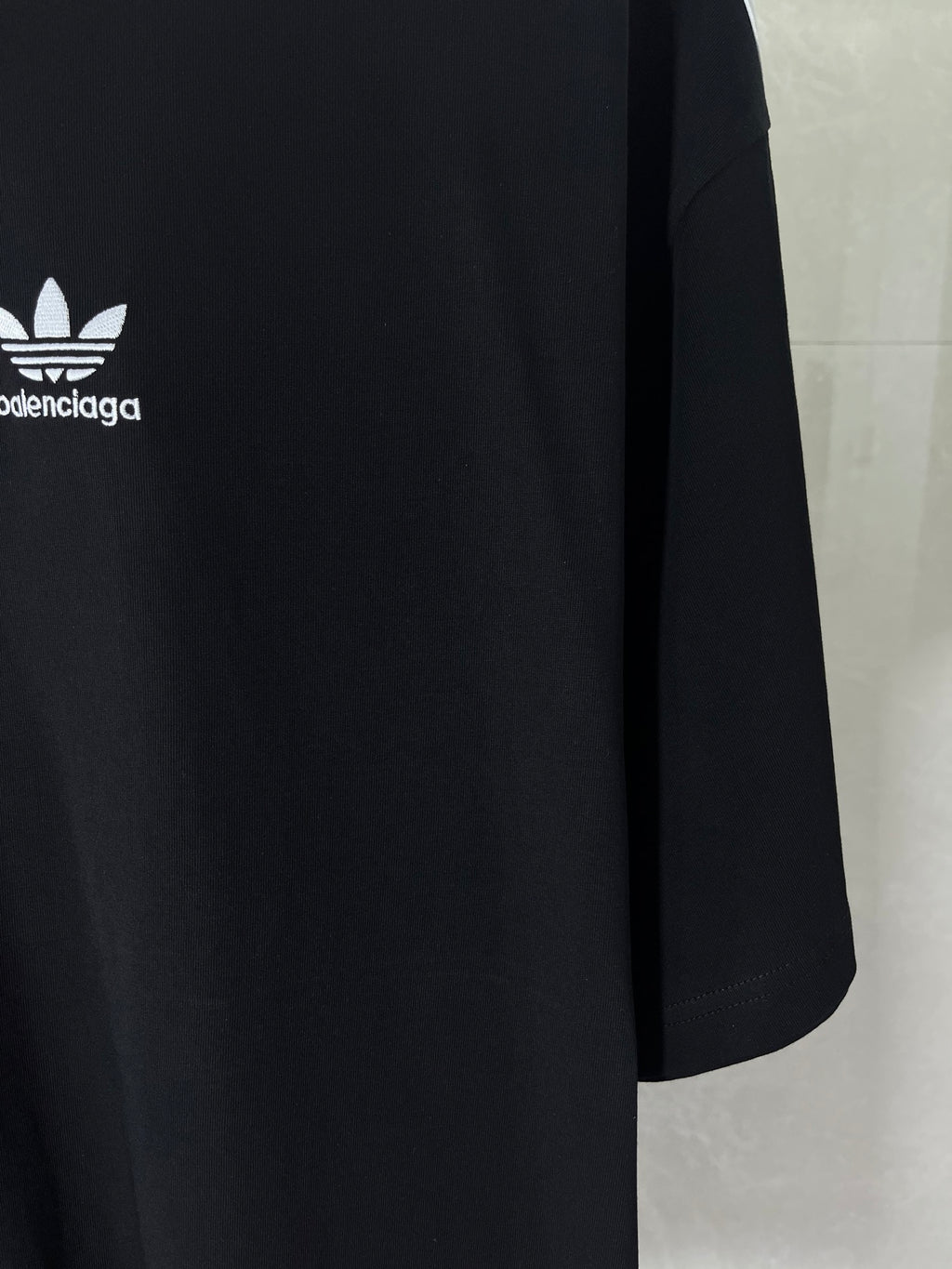 Short-sleeve T-shirt fabric and side seam close-up with partial logo