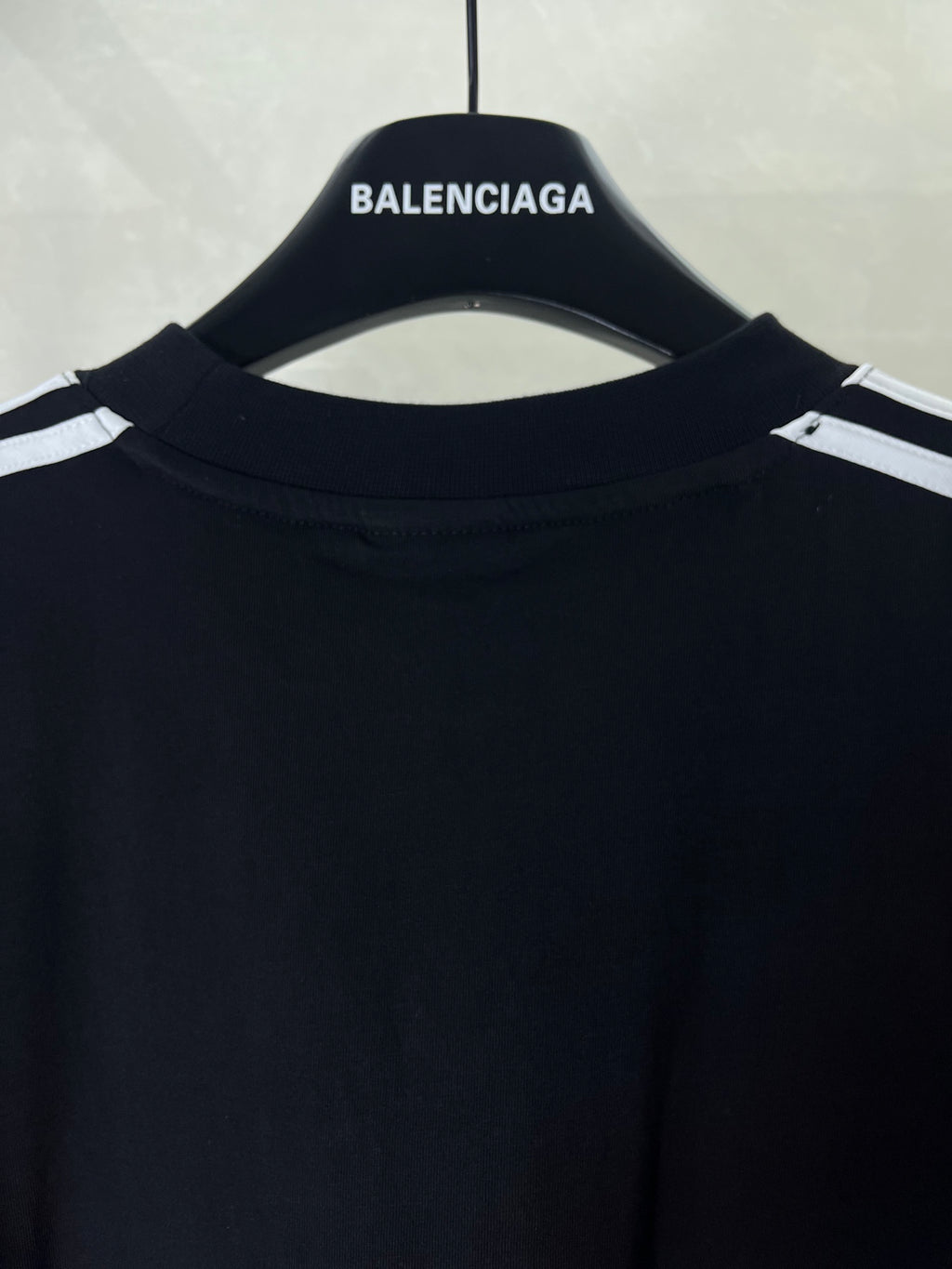 Short-sleeve T-shirt neckline close-up in dark fabric with small logo