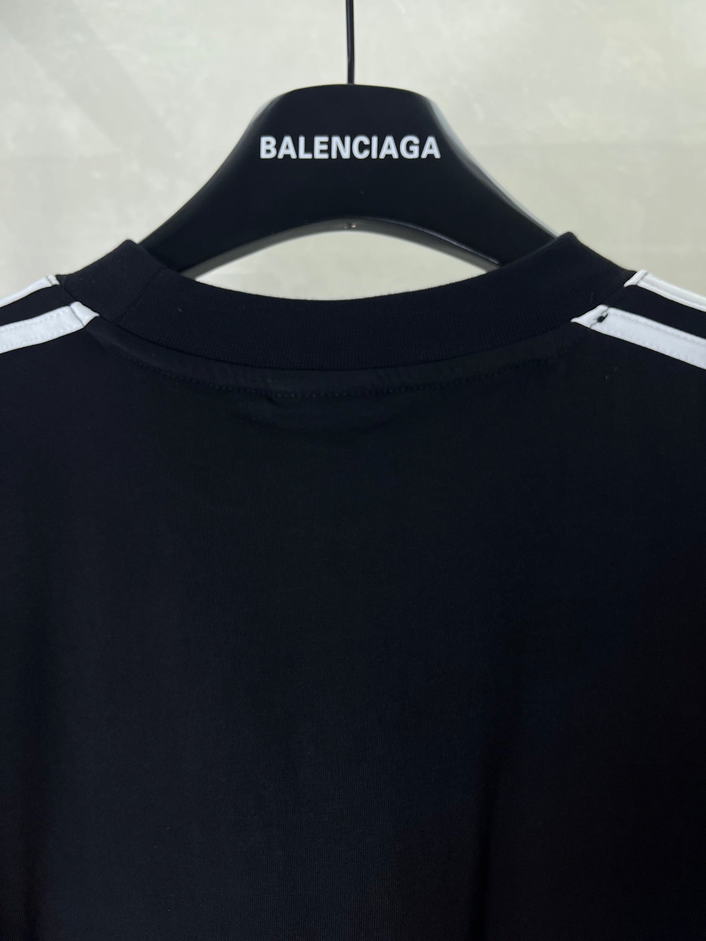 Short-sleeve T-shirt neckline close-up in dark fabric with small logo