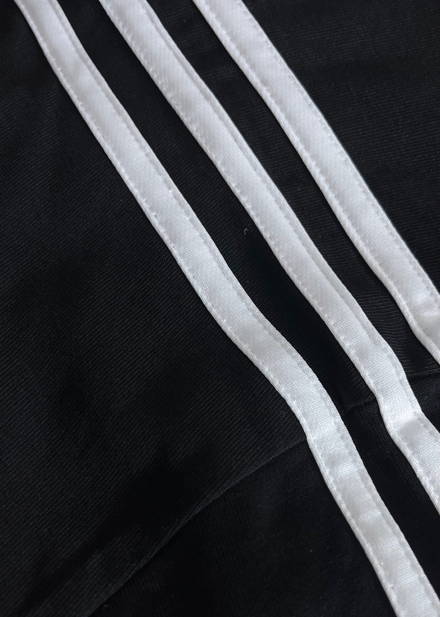 Short-sleeve T-shirt sleeve stripes close-up in white on dark fabric