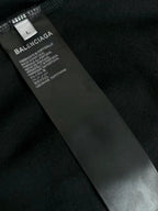 Black garment label with size L and Balenciaga text, care information.