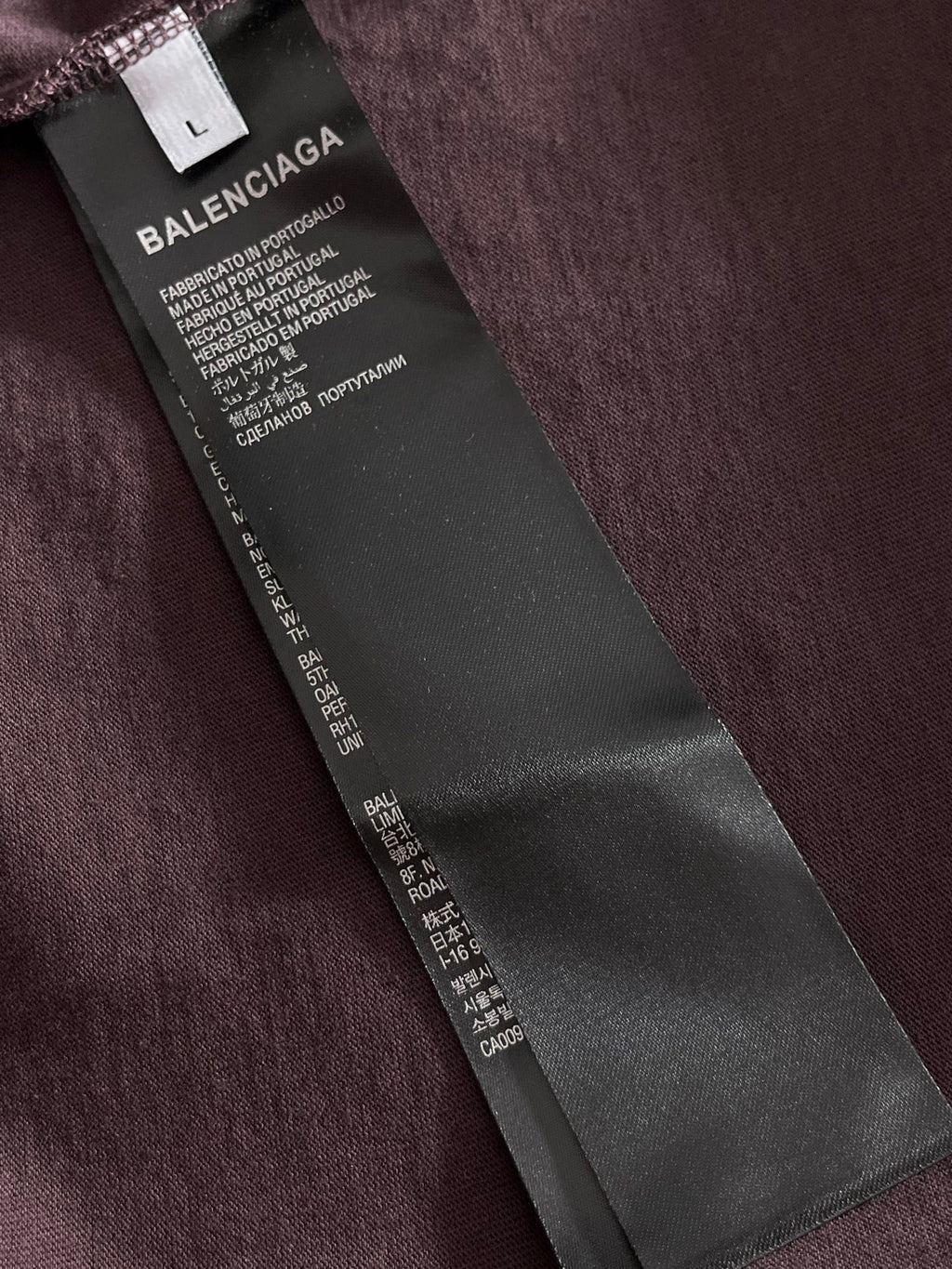 Balenciaga T-shirt hang tag on dark purple fabric