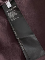 Balenciaga T-shirt hang tag on dark purple fabric