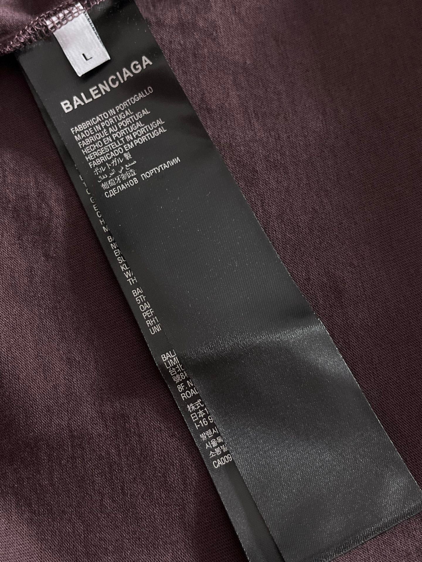 Balenciaga T-shirt hang tag on dark purple fabric