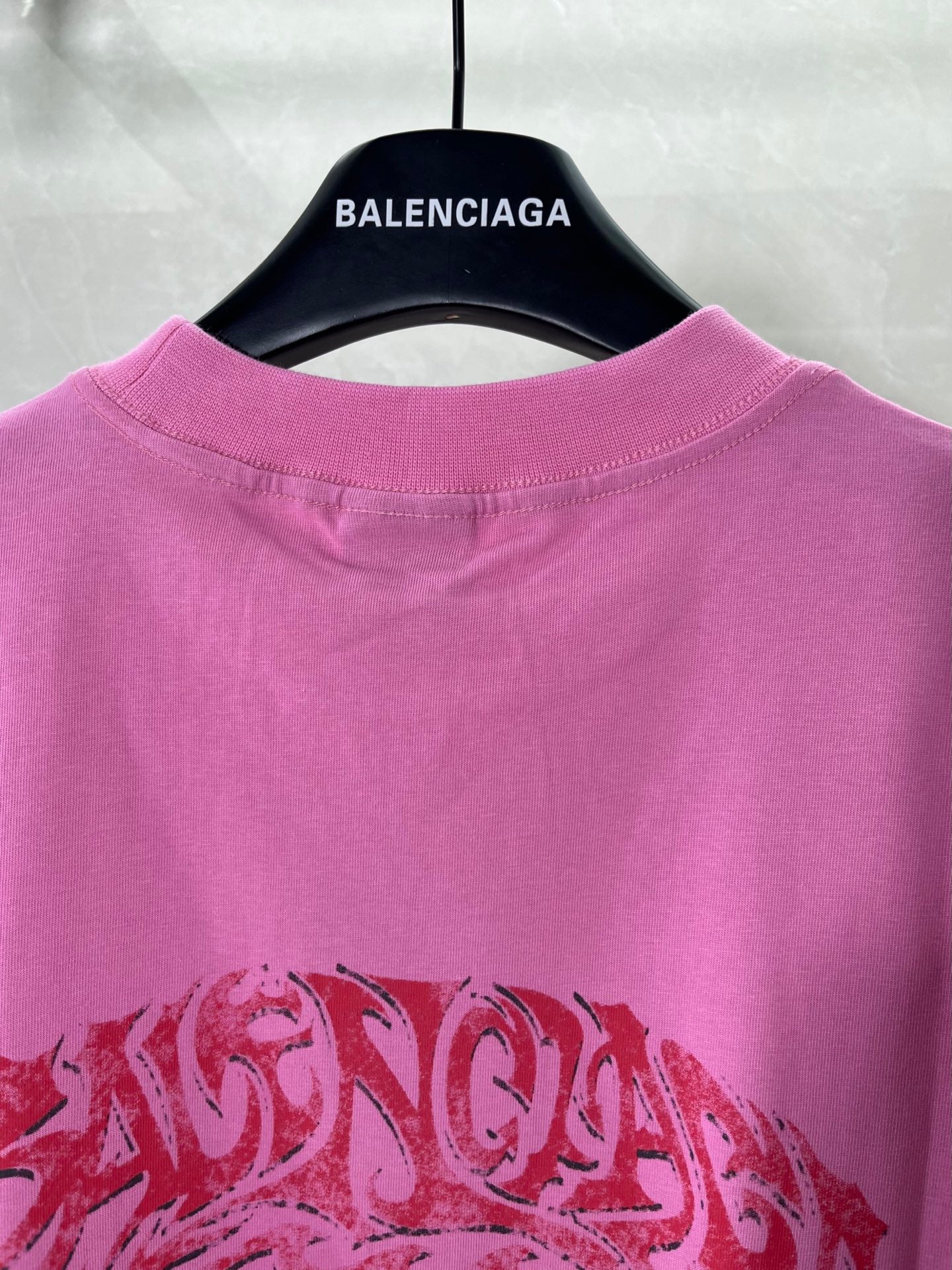 Pink Balenciaga crew-neck T-shirt with red logo-style graphic on the front