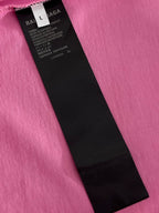 Balenciaga garment tag attached to a pink T-shirt