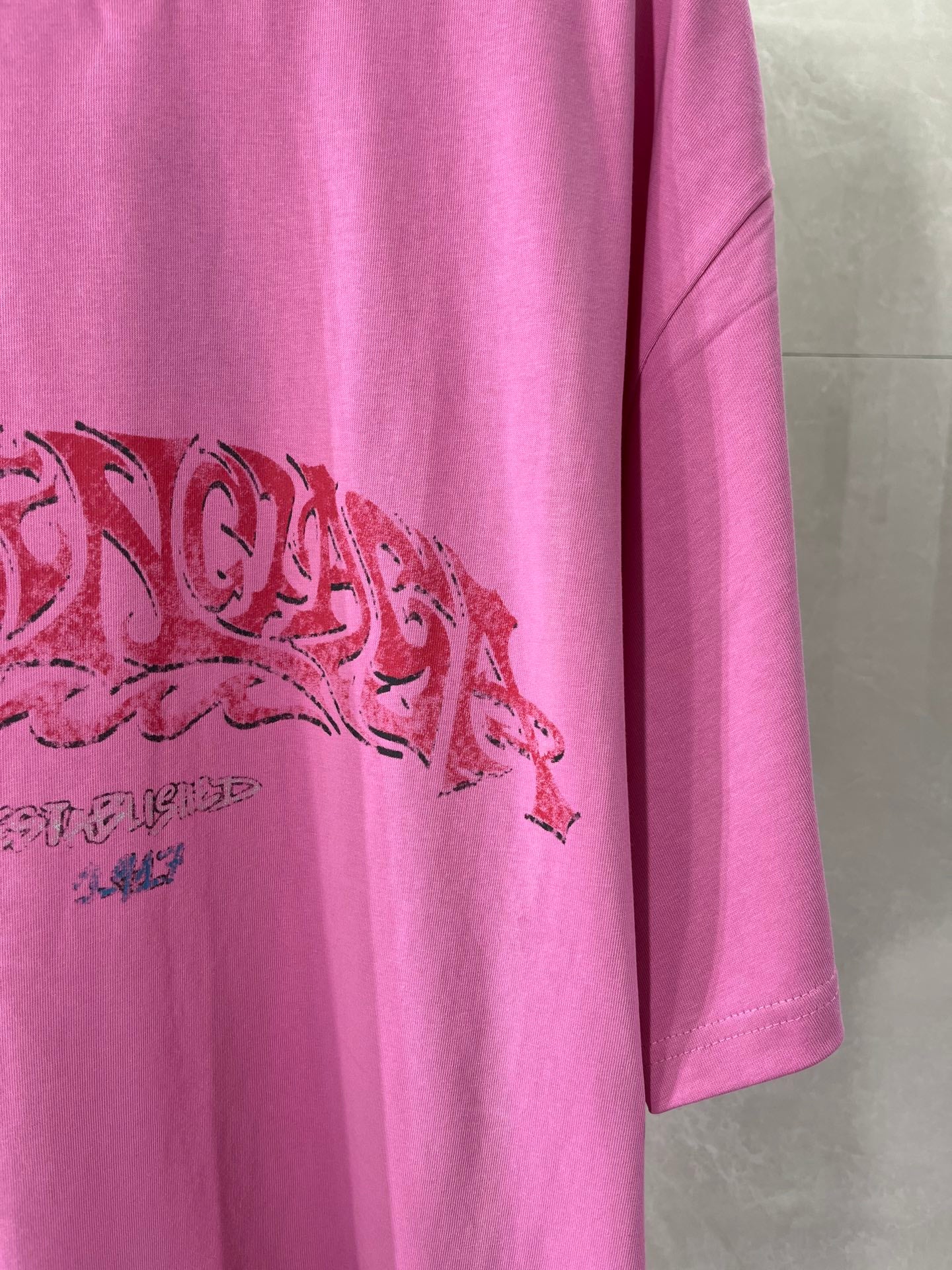Pink Balenciaga T-shirt with red graphic print on the front and short sleeve
