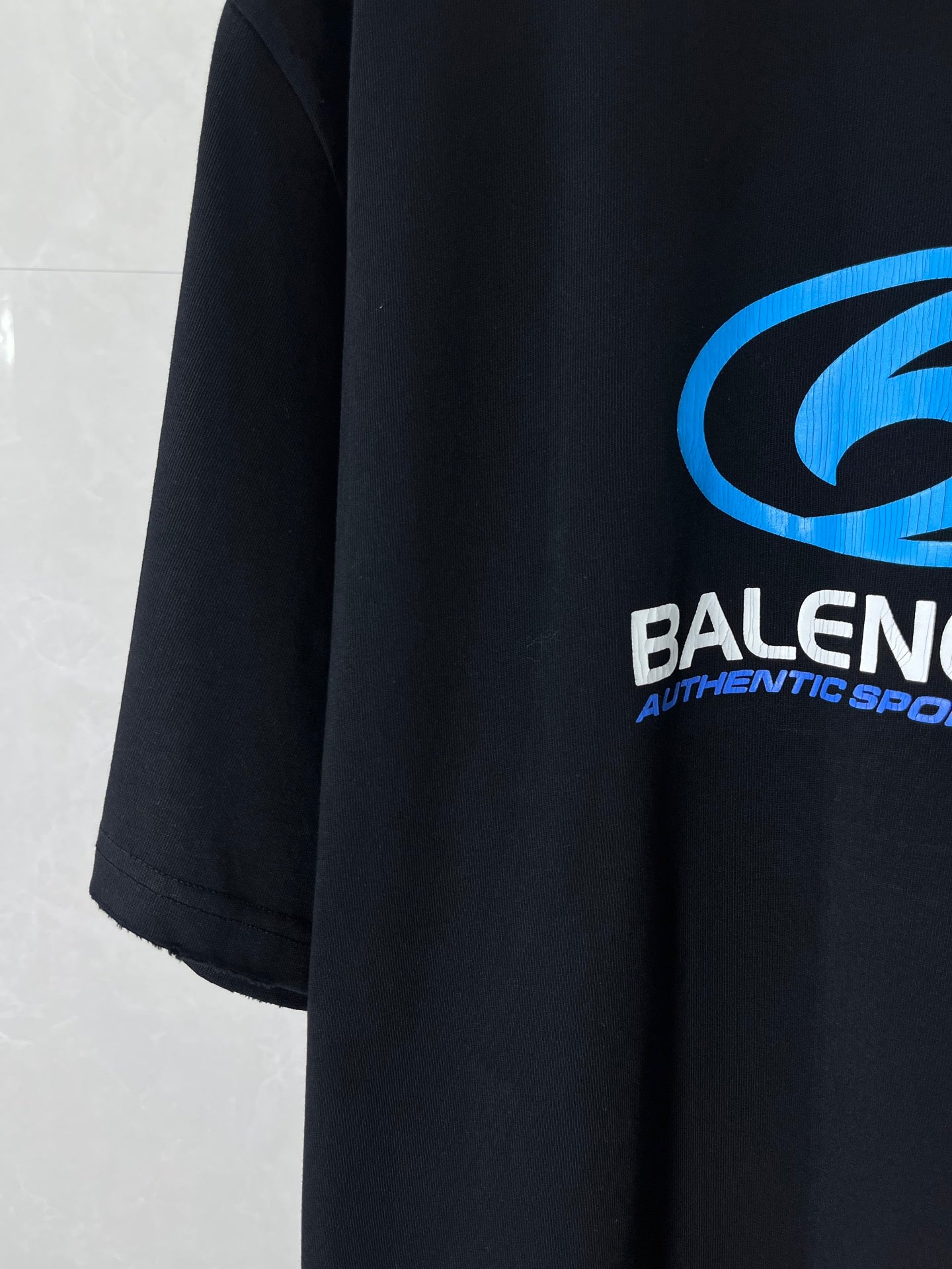 Black Balenciaga T-shirt sleeve with blue logo and white text print