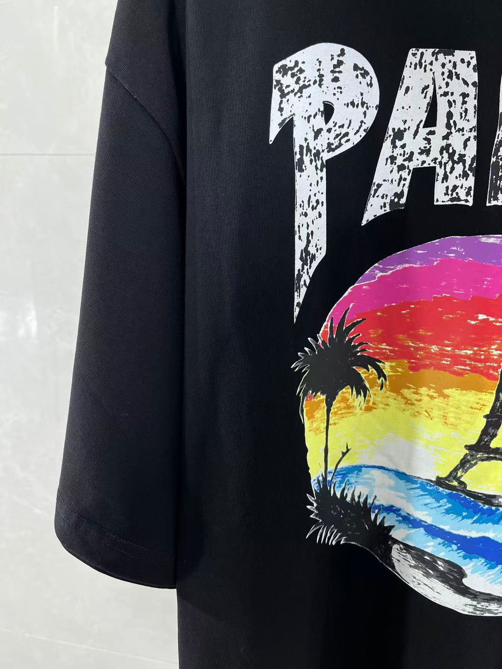 Black T-shirt sleeve with part PARIS graphic featuring palms and Eiffel Tower