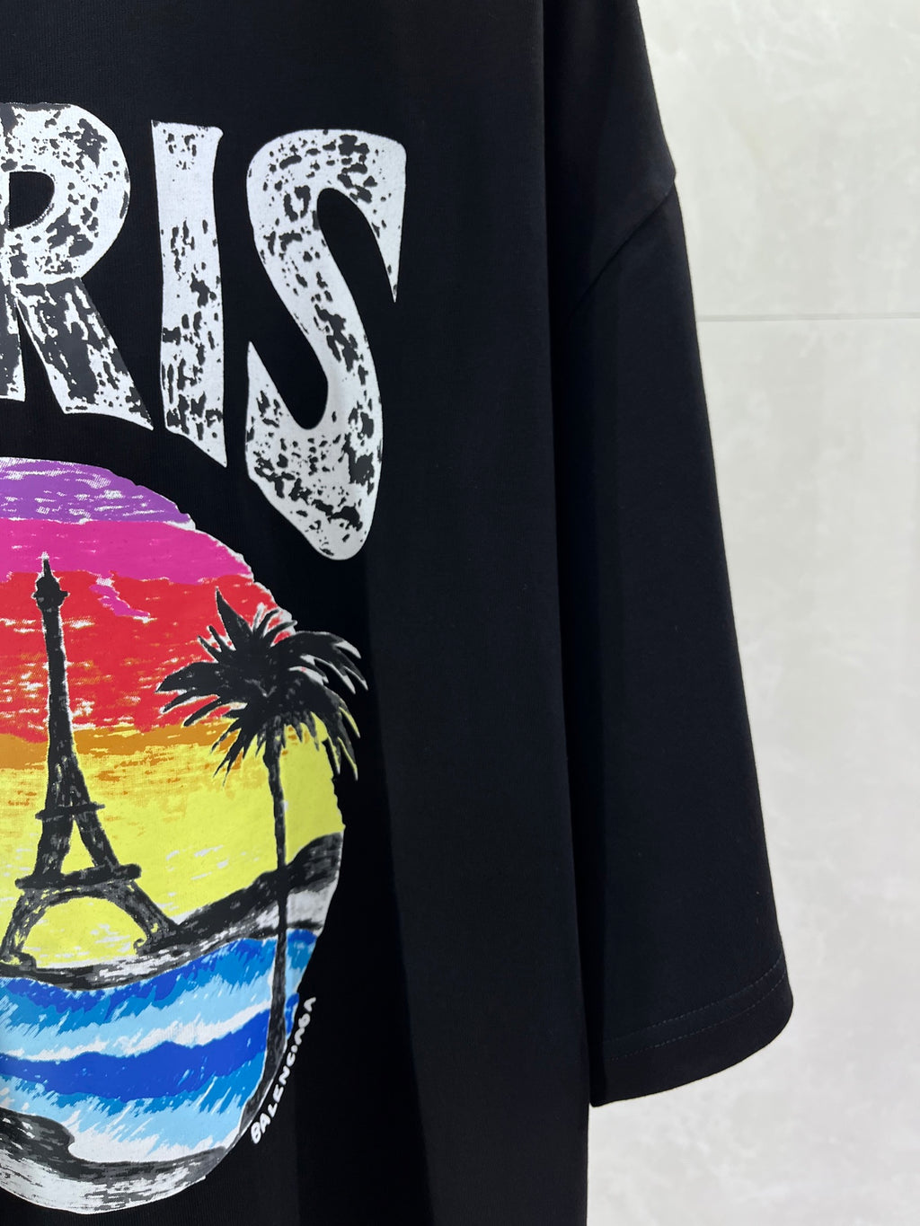 Black T-shirt front with PARIS lettering and colorful skyline graphic