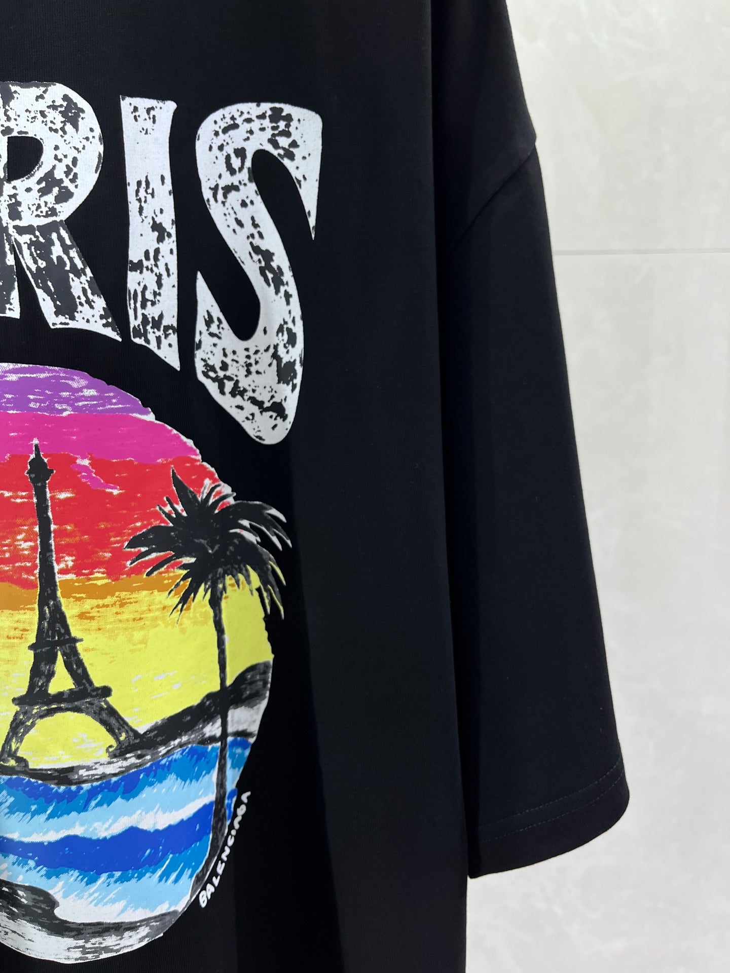 Black T-shirt front with PARIS lettering and colorful skyline graphic