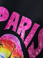 Balenciaga black T-shirt close-up of large pink PARIS lettering and beach scene