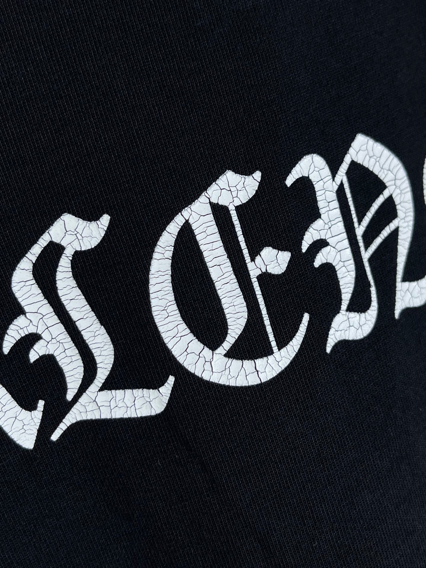 Balenciaga black T-shirt with cracked white lettering across the chest