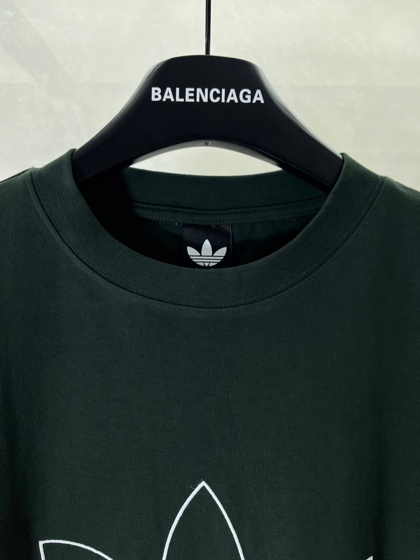 Dark green T-shirt crew neck with small adidas trefoil logo at neckline