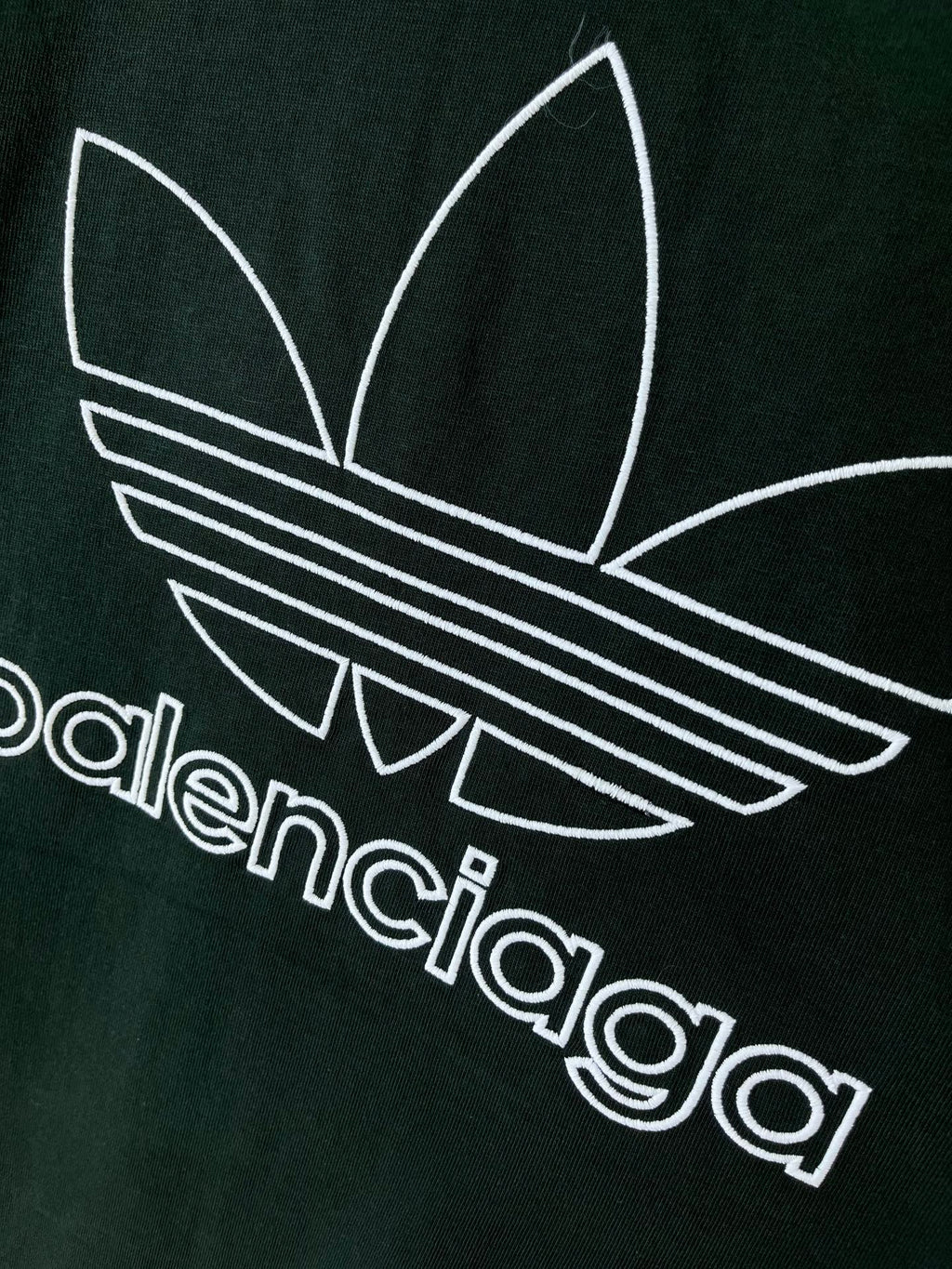 Dark green T-shirt chest graphic with adidas trefoil and striped logo in white