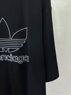 Balenciaga T-shirt sleeve and side graphic with white trefoil logo on dark fabric