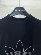Balenciaga T-shirt neckline with white trefoil graphic outline on dark fabric