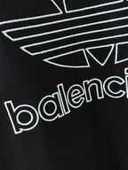 Balenciaga T-shirt close-up of white trefoil lines and balenciaga text on dark