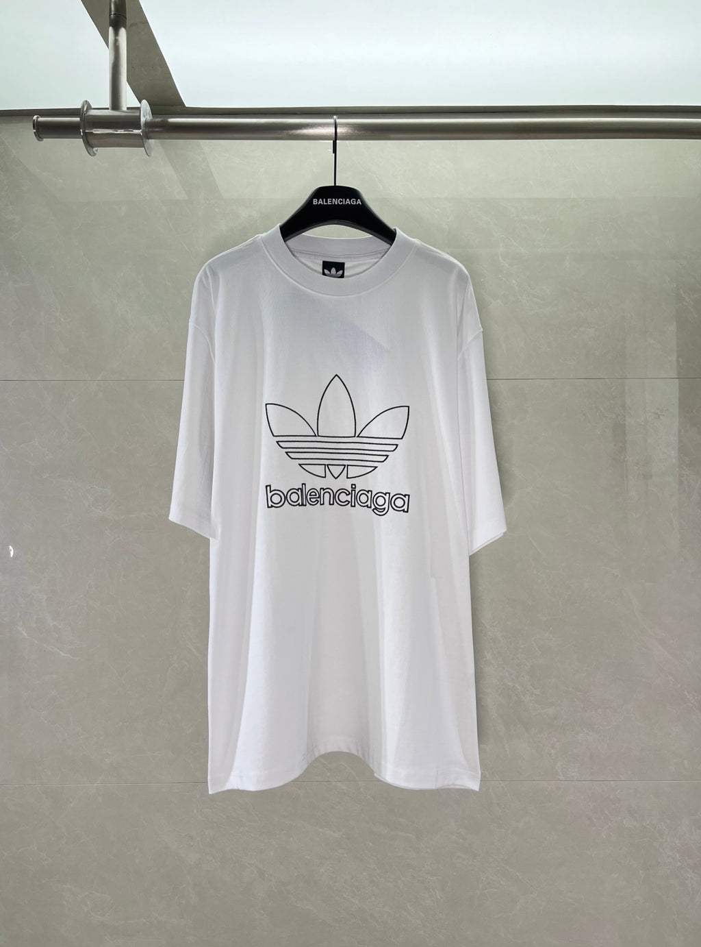 White Balenciaga graphic logo T-shirt with large trefoil-style emblem on chest.