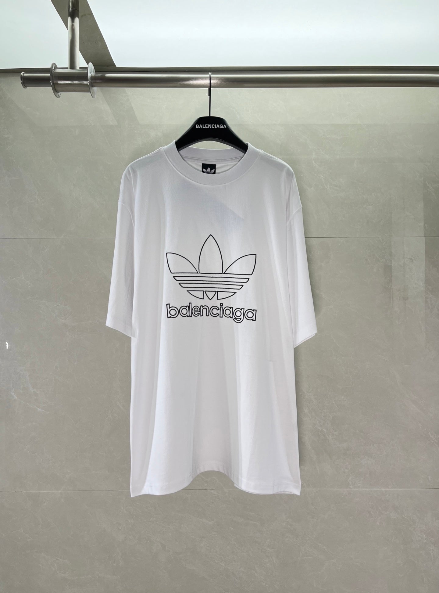 White Balenciaga graphic logo T-shirt with large trefoil-style emblem on chest.