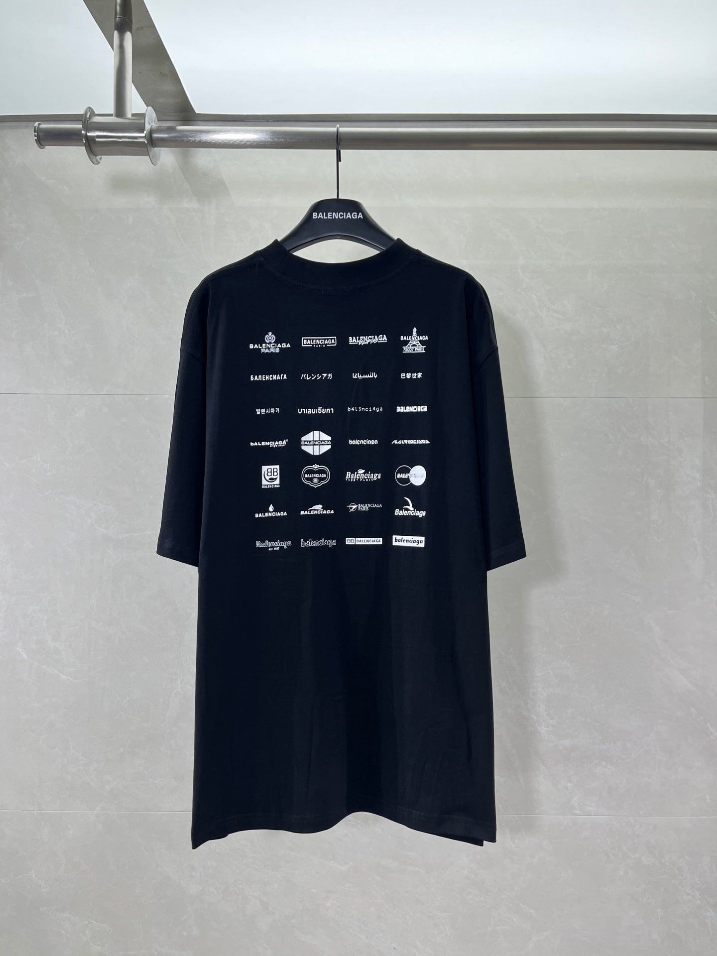 Dark crew-neck T-shirt with short sleeves and repeating Balenciaga logo graphics on back