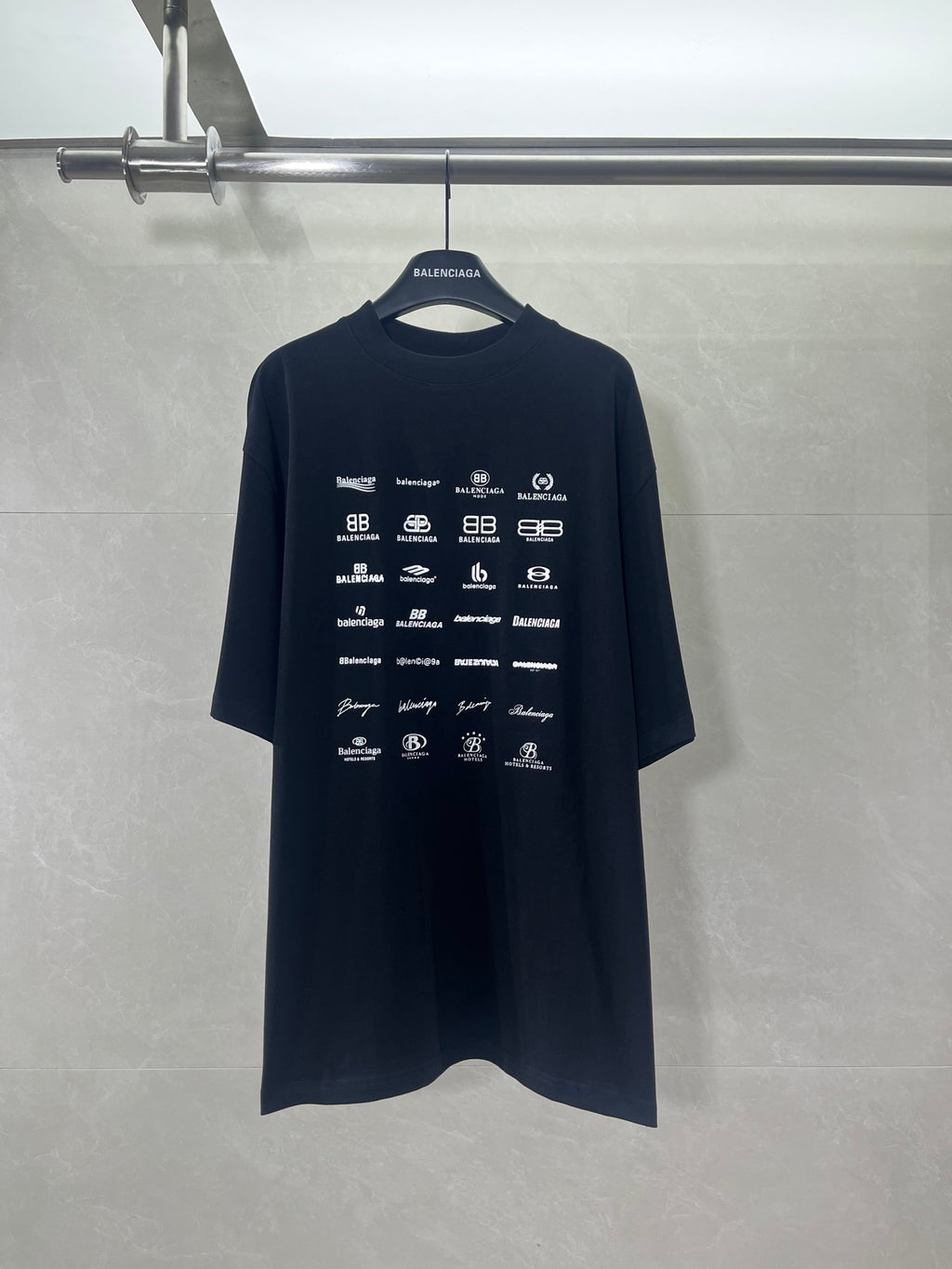 Dark crew-neck T-shirt with short sleeves and repeating Balenciaga logo graphics