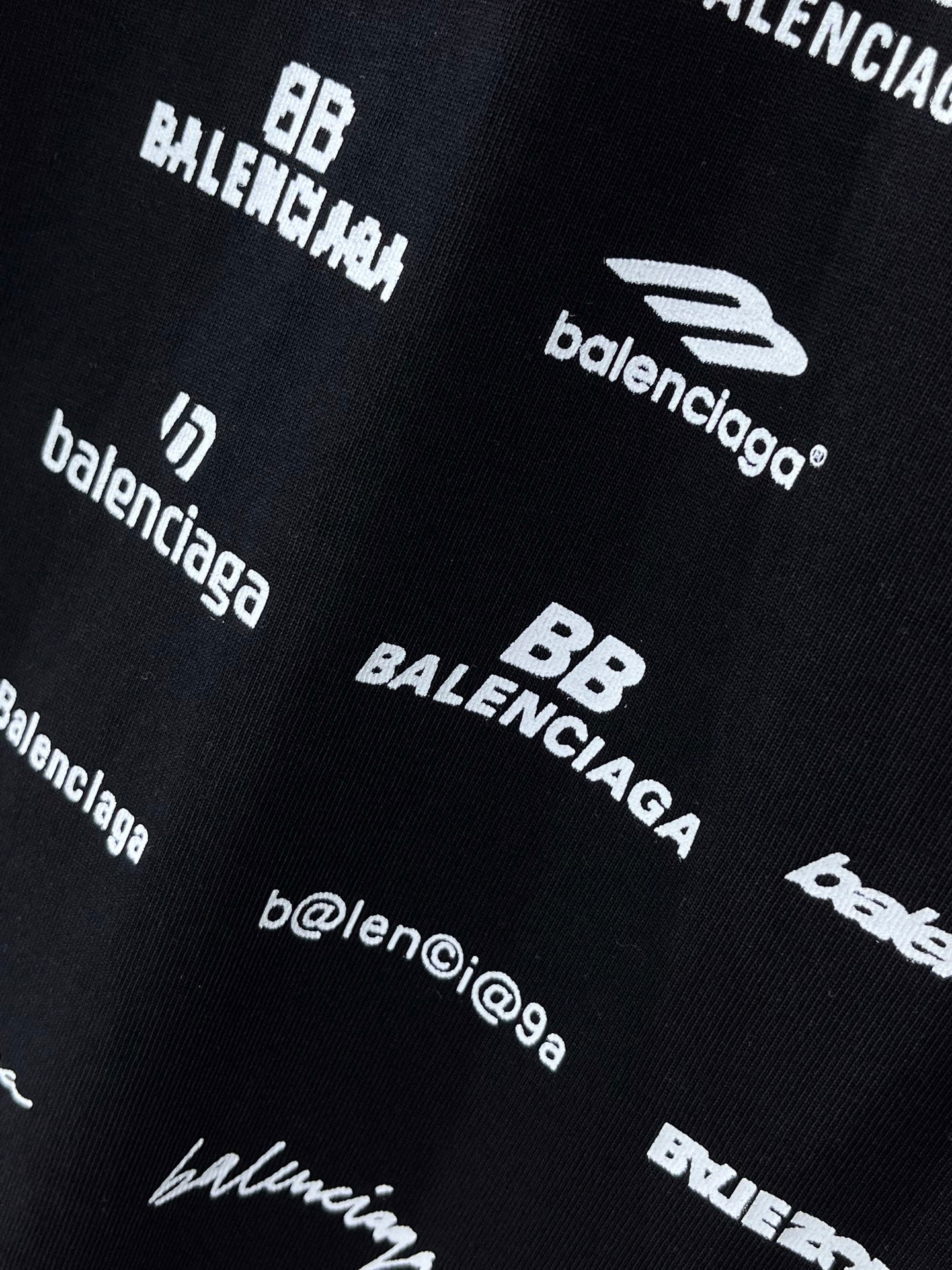 Dark T-shirt fabric close-up with Balenciaga and HLECHIUM graphics