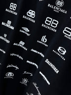 Dark T-shirt fabric close-up with white Balenciaga logo pattern