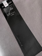 Balenciaga clothing care label tag attached inside neck