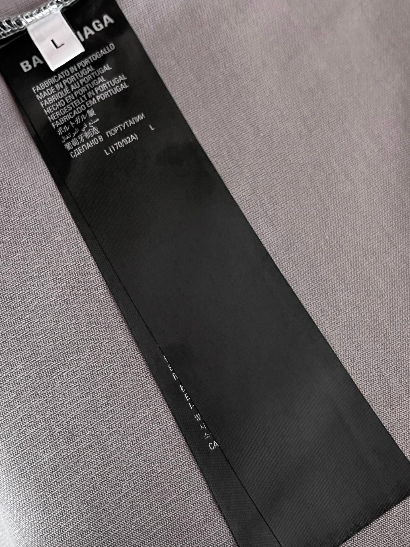 Balenciaga clothing care label tag attached inside neck