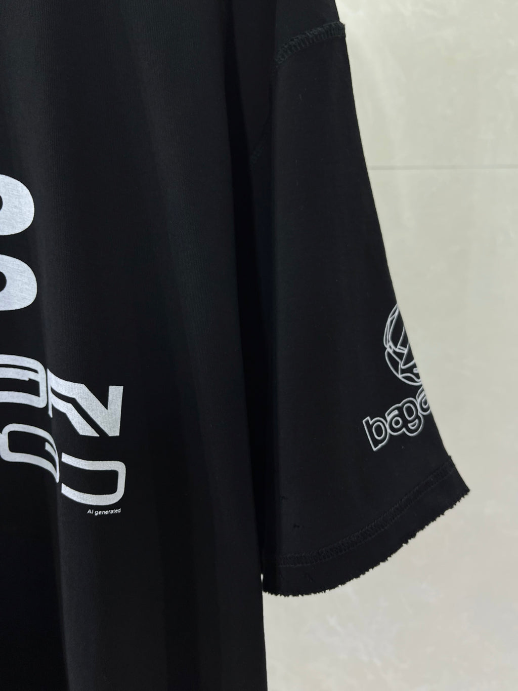 Balenciaga black T-shirt sleeve detail with printed logo and hem