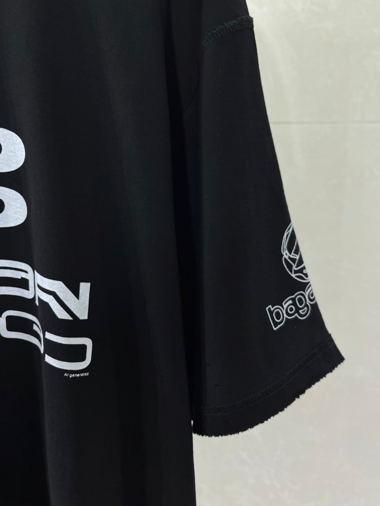 Balenciaga black T-shirt sleeve detail with printed logo and hem