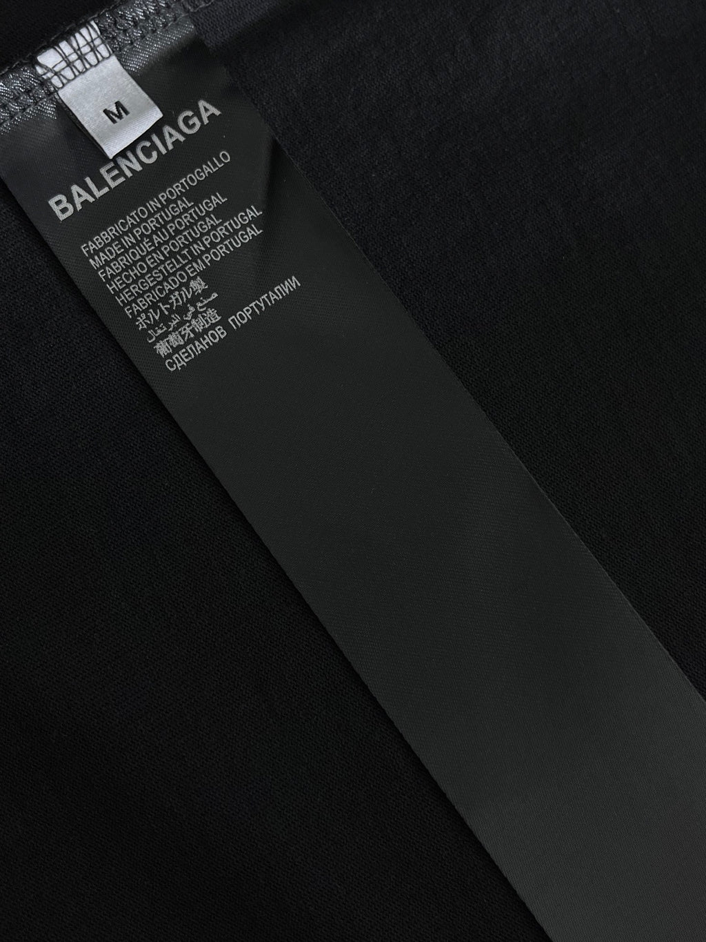 Balenciaga fabric tag on dark T-shirt with brand and care information