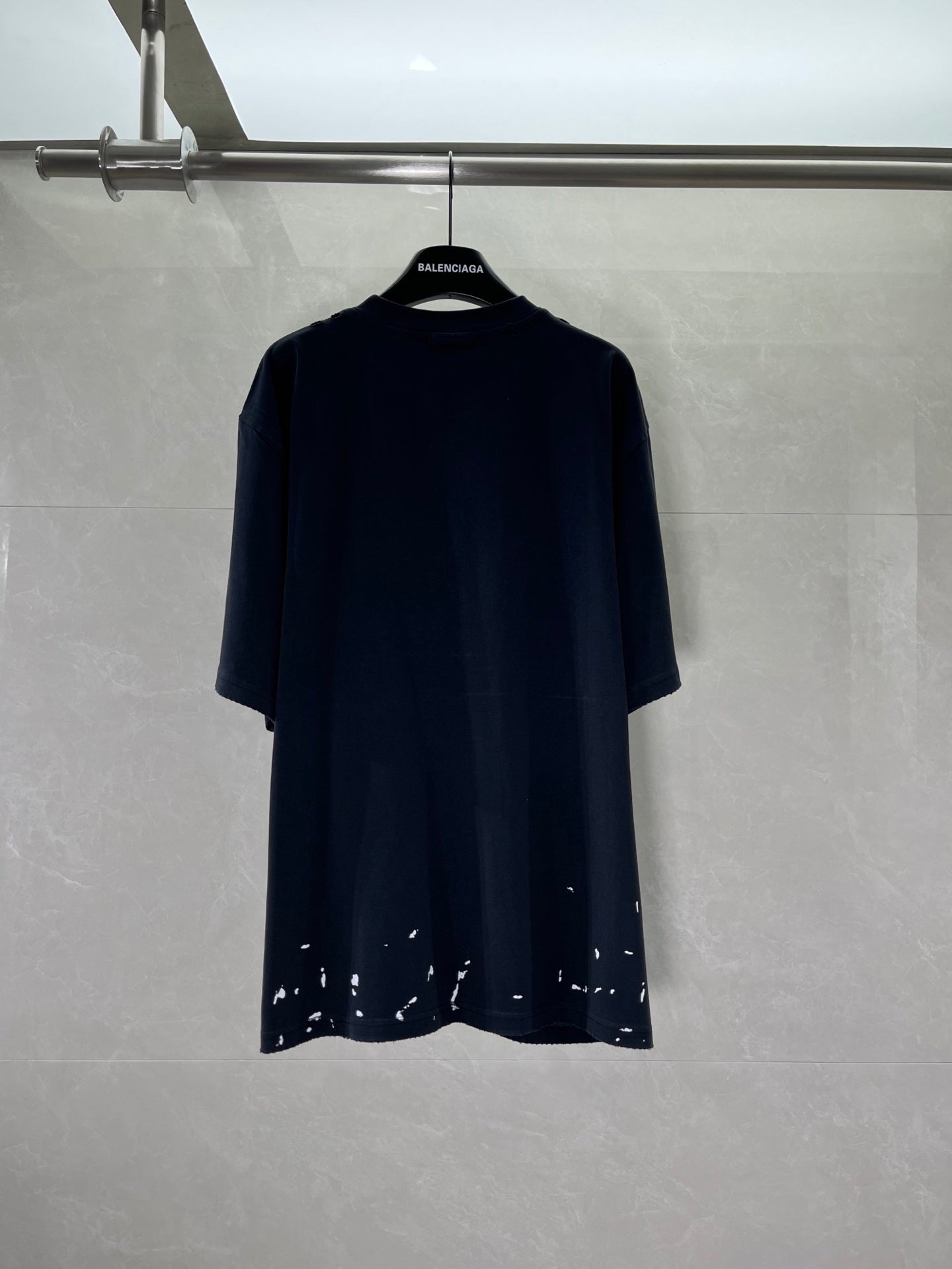Short-sleeve T-shirt in dark navy/black with distressed speckled hem, no visible front print
