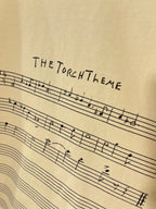 Balenciaga cream T-shirt close-up of THE TORCH THEME musical staff