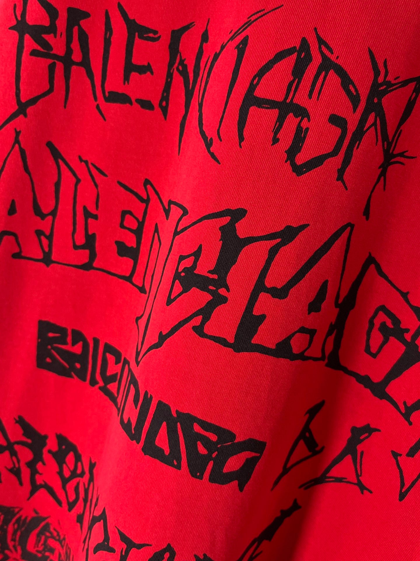 Red T-shirt fabric close-up with black graphic typography