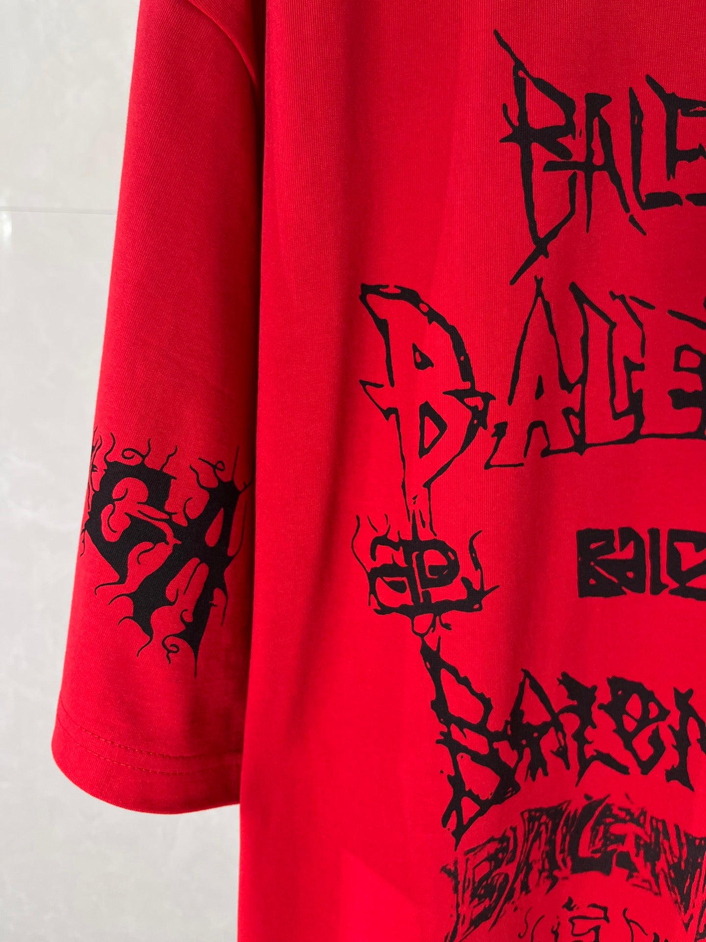 Red T-shirt sleeve panel with black graphic lettering print