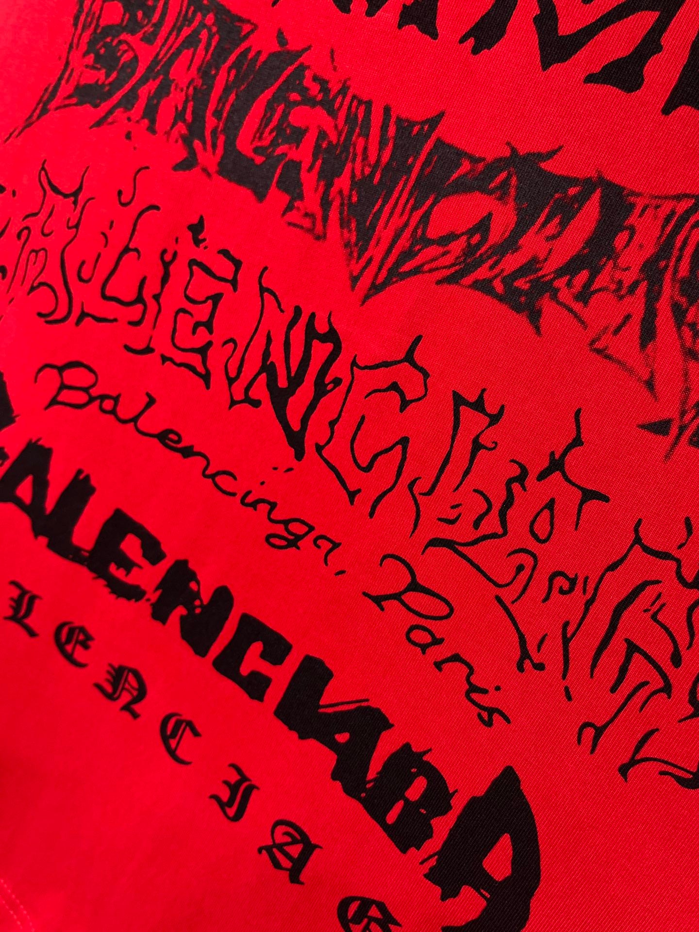 Red T-shirt close-up with black graffiti-style lettering pattern