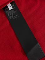 Red T-shirt fabric with black size and care label at collar seam