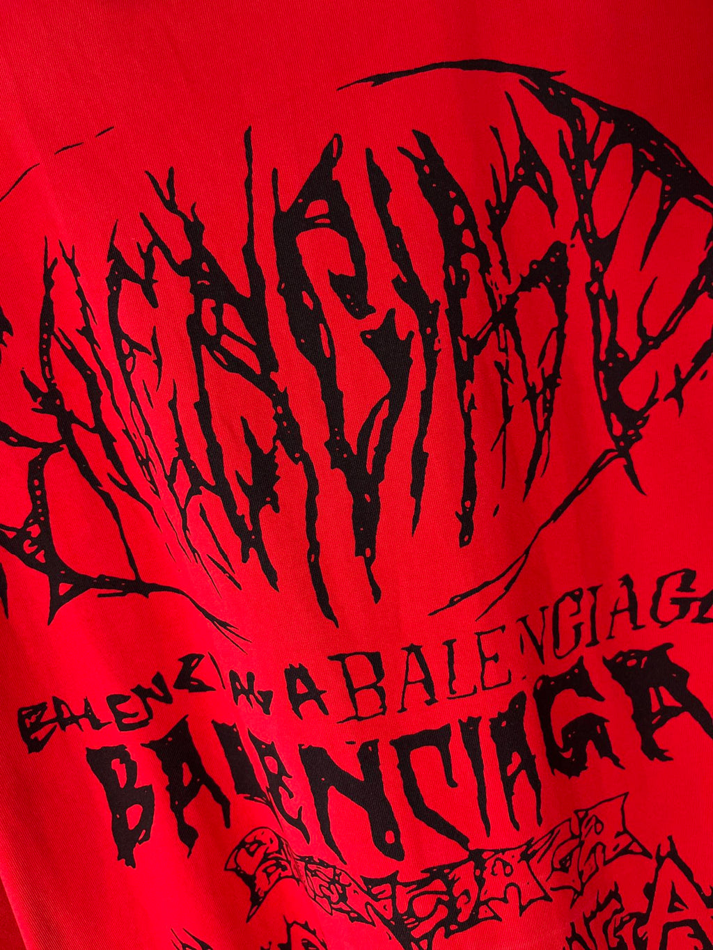 Red T-shirt close-up with large black graphic wordmark text
